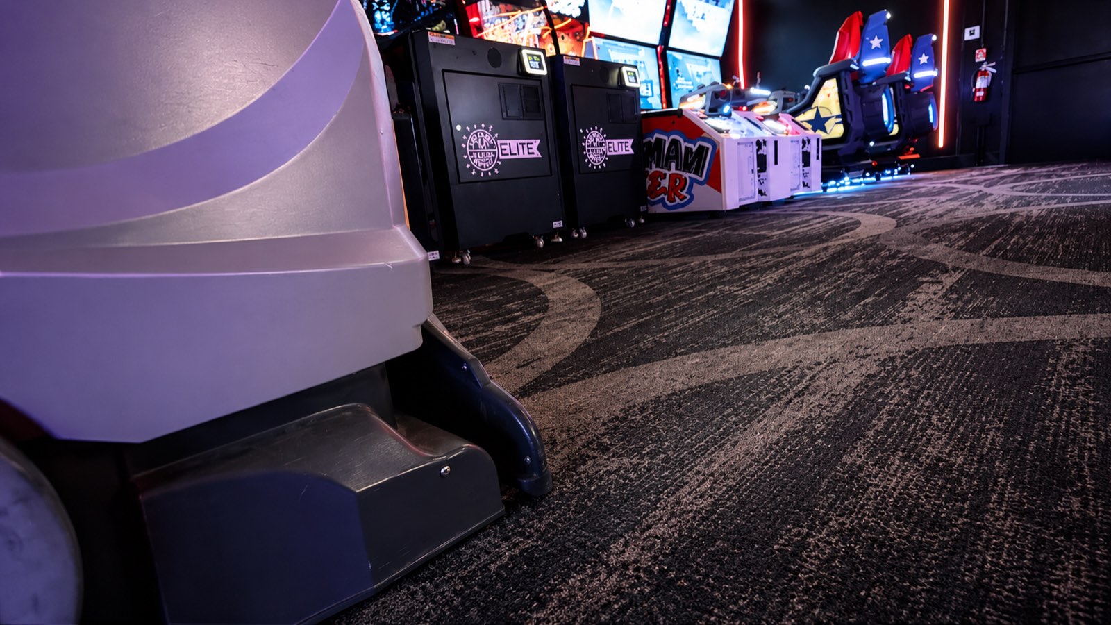 Carpet extractor working the floor between arcade cabinets
