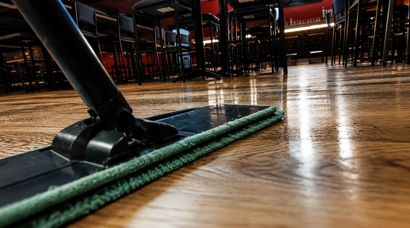 Microfiber mop on a polished wood floor in a dining area