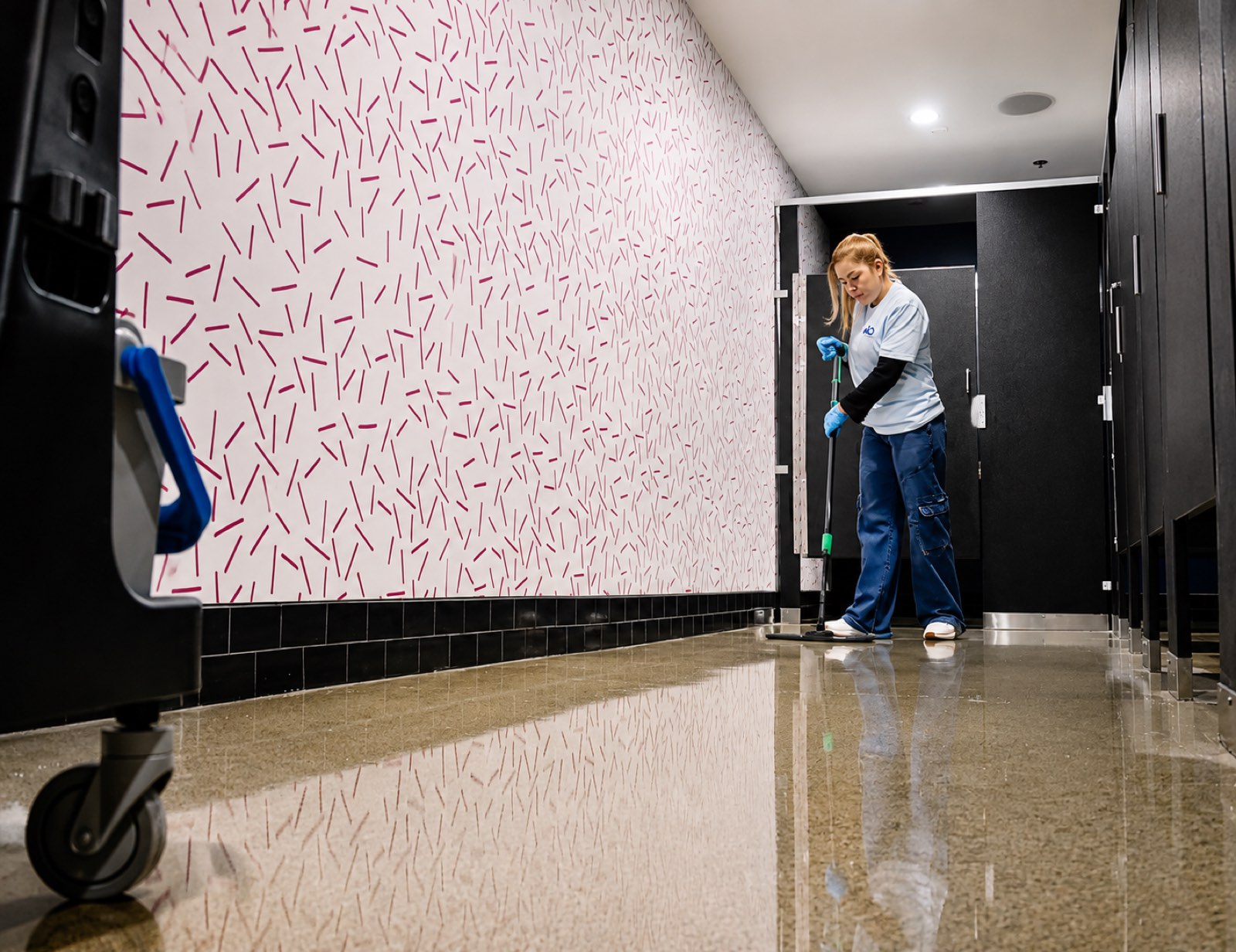 AQS team member mopping a restroom corridor