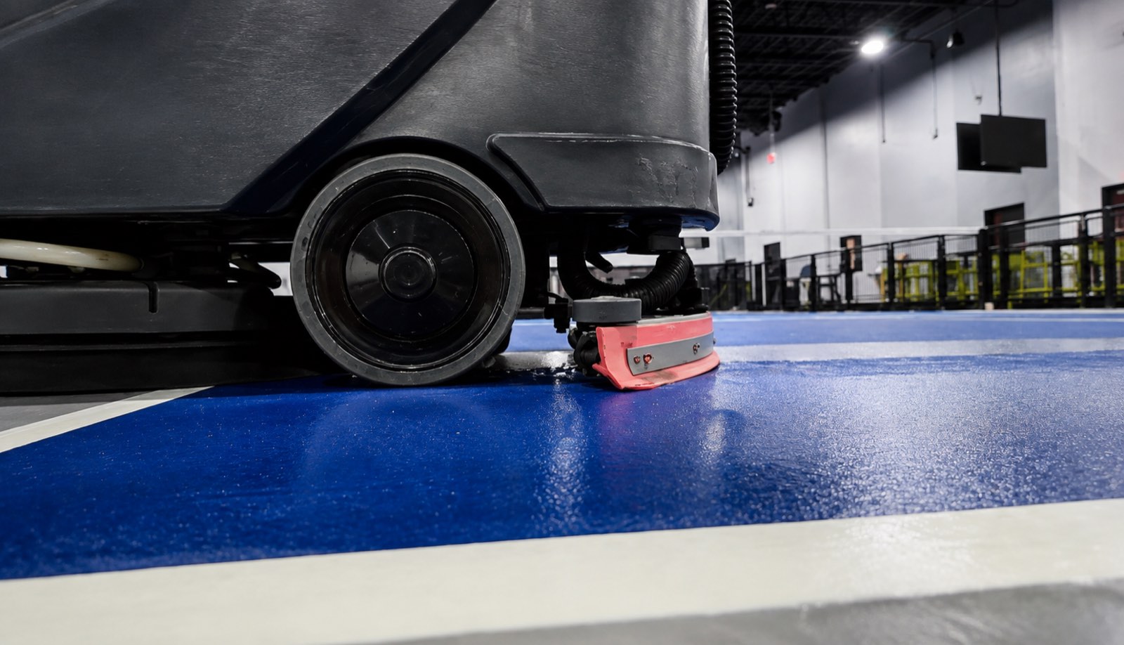 Floor scrubber squeegee drying a blue sport court