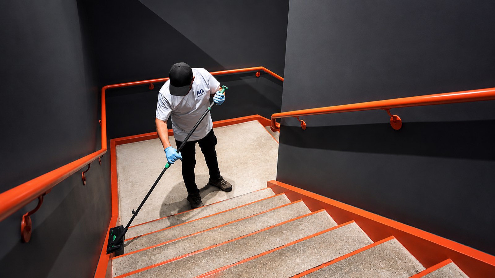 AQS team member dust-mopping a stairwell