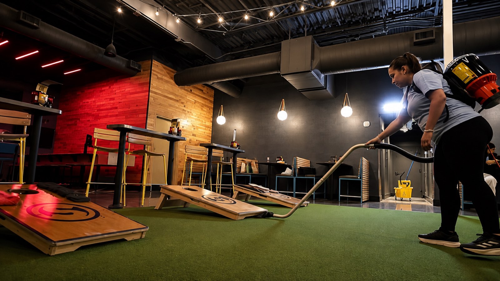 Backpack vacuum cleaning indoor turf around cornhole boards